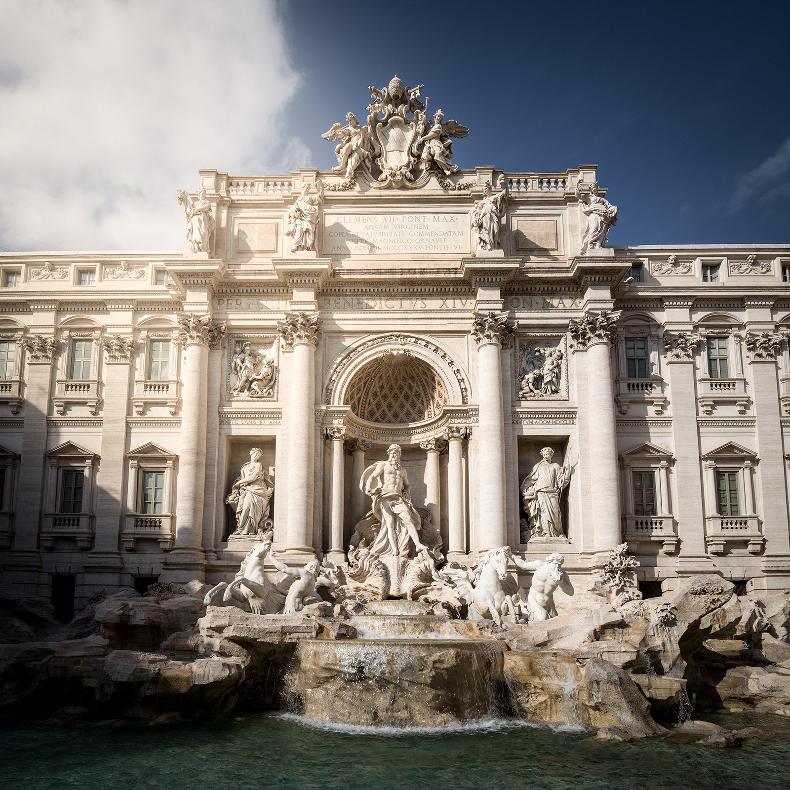 Rome - An ornate stone fountain with statues and cascading water fills the frame beneath a deep blue sky and soft clouds. - #Rome #Roma #Italy #RomeItaly #VisitRome #RomeTravel #TravelRome #ExploreRome #ItalyTravel #VisitItaly