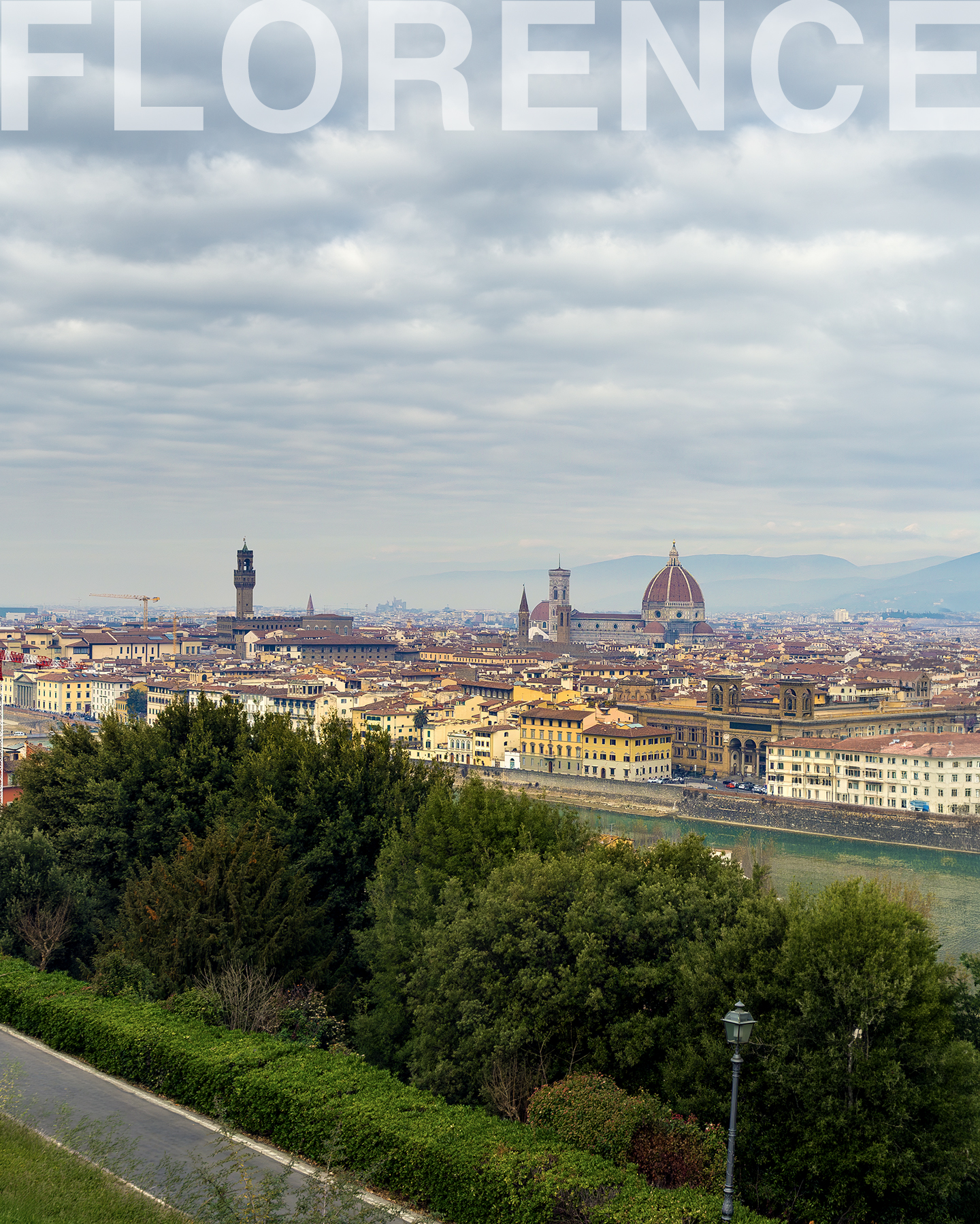 Florence - A panoramic city skyline with a domed cathedral, riverfront buildings, green foreground, and heavy clouds. - #Cityscape #Skyline #Architecture #Cathedral #Dome #Riverfront #CloudySky #Panorama #TravelPhotography #UrbanLandscape