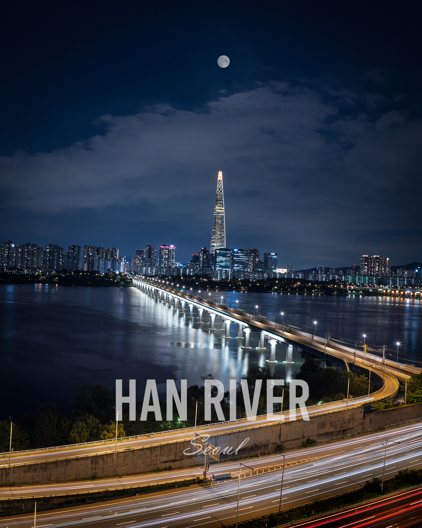 Han River - A moonlit city skyline rises beyond a broad river, with a lit bridge and highway light trails cutting through the night. - #HanRiver #Hangang #HanRiverNight #HangangNightView #SeoulNight #SeoulNightView #SeoulNightscape #SeoulSkyline #SeoulCityscape #SeoulLights