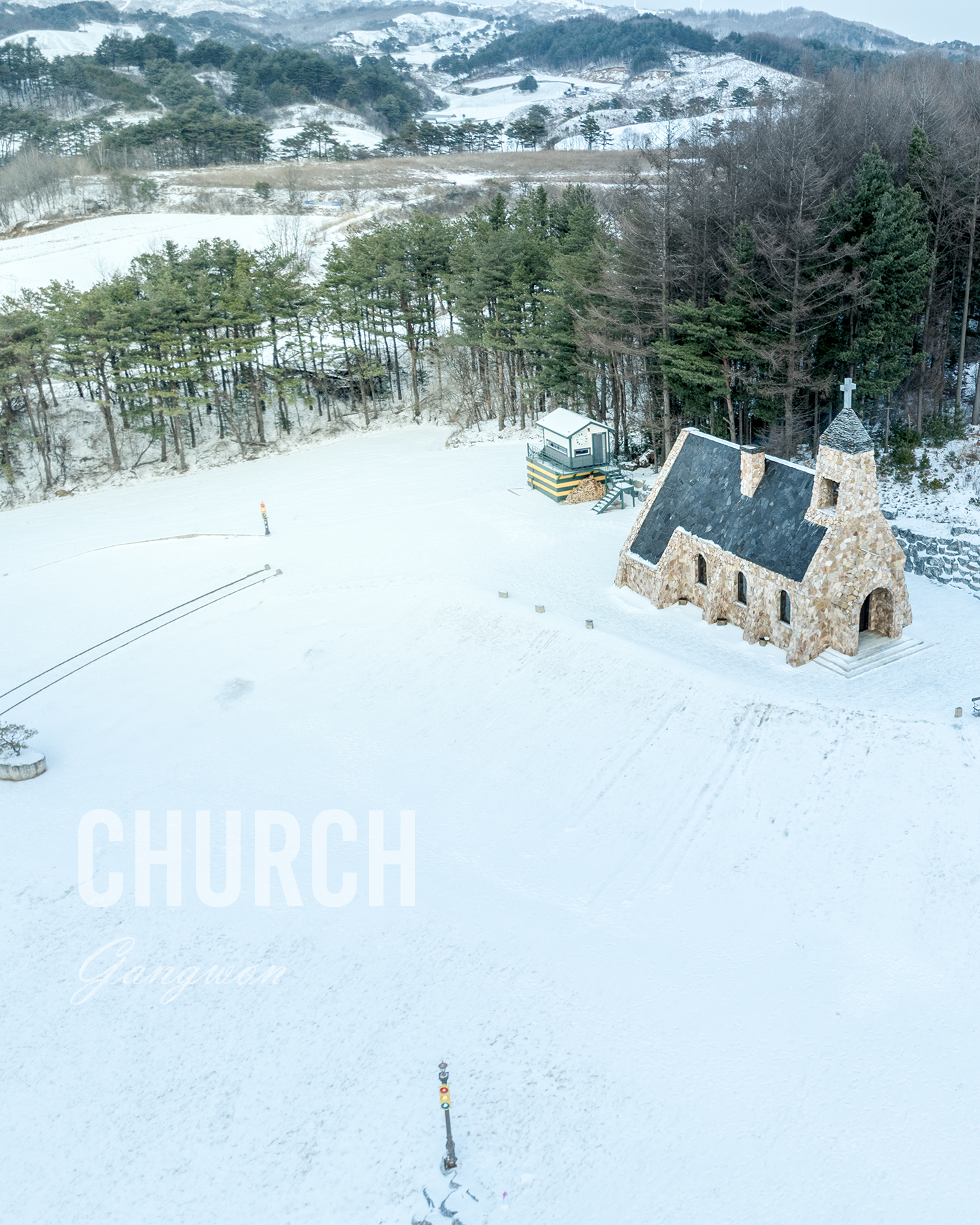 Church - A small stone church with a cross stands in a snowy clearing beside dark trees and rolling winter hills under soft overcast light. - #SilverBellChurch #Daegwallyeong #Pyeongchang #GangwonDo #KoreaChurch #ChurchPhotography #ChurchArchitecture #BeautifulChurch #CountrysideChurch #KoreanLandsc