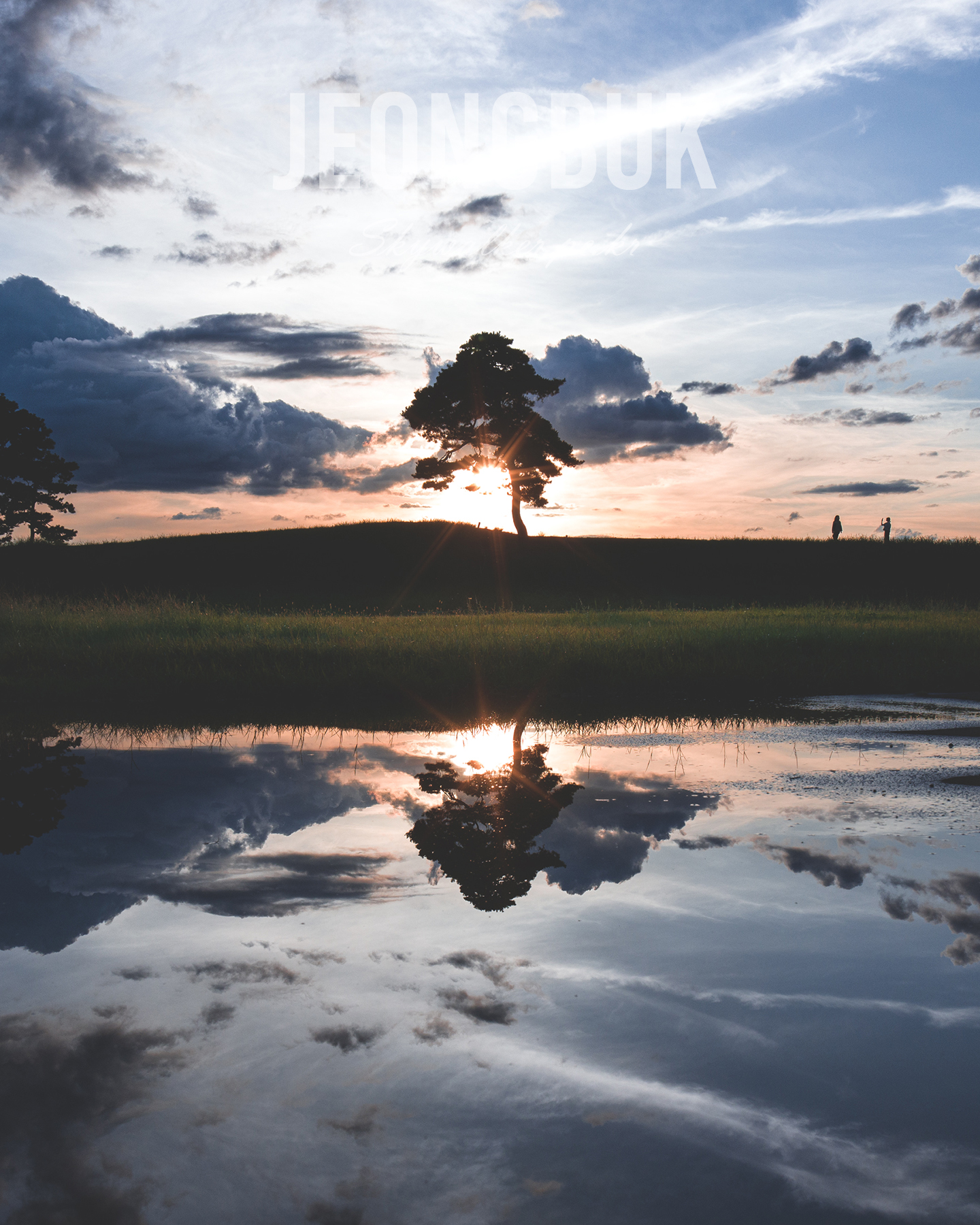 Jeongbuk Fortress - A lone tree is silhouetted at sunset on a grassy ridge, mirrored in still water beneath a cloud-filled sky. - #Sunset #Silhouette #Tree #Reflection #Clouds #Sky #Water #Landscape #Dusk #Nature