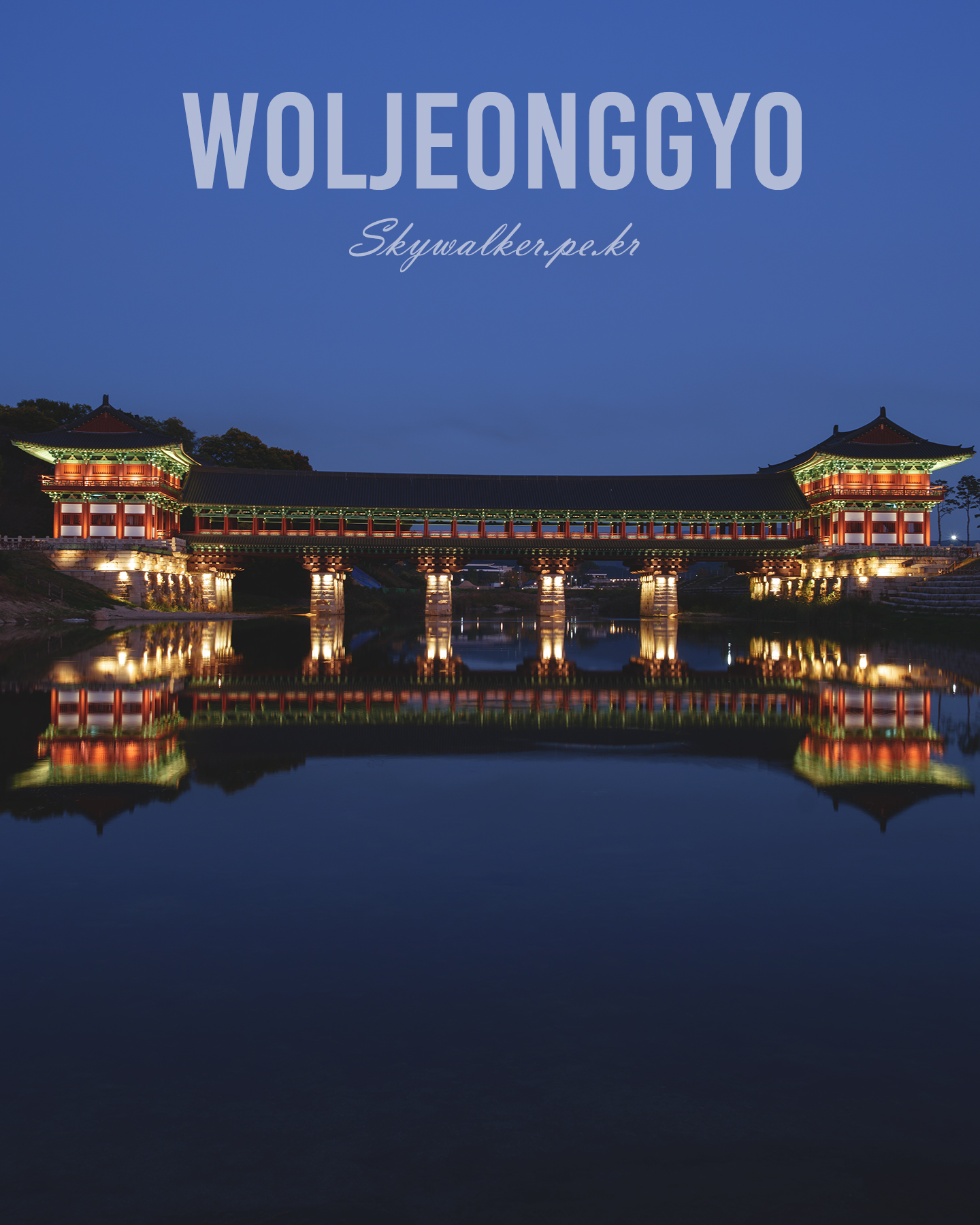 Woljeonggyo - An illuminated traditional covered bridge spans calm water at dusk, creating a symmetrical reflection under a deep blue sky. - #Woljeonggyo #TraditionalBridge #NightPhotography #Reflection #BlueHour #Illuminated #Architecture #WaterReflection #KoreanArchitecture #Symmetry
