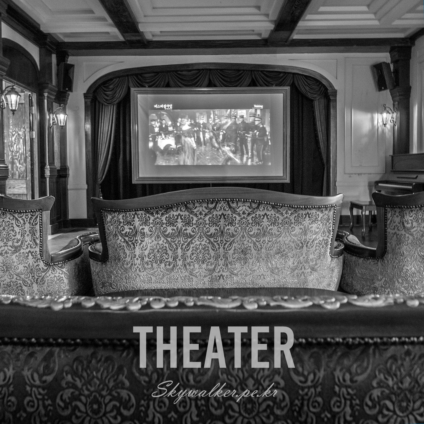 Theater - An ornate monochrome theater interior shows patterned seats facing a curtained projection screen under soft wall lights. - #theater #cinema #monochrome #interior #projection #curtains #seating #ornate #vintageStyle #softLight