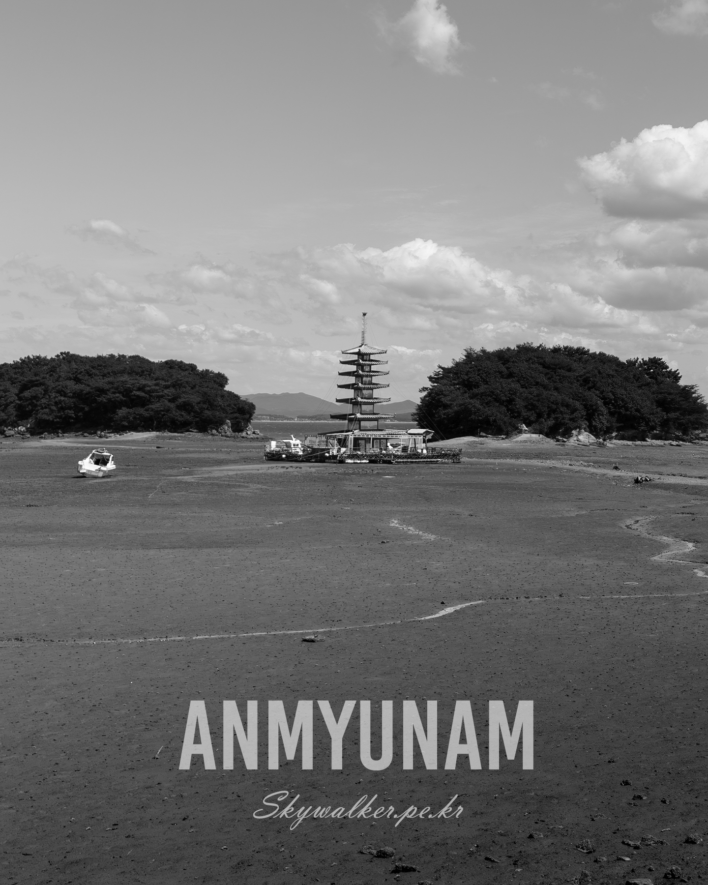 Anmyunam - A pagoda-like structure stands on a wide tidal flat between wooded islets under a bright blue, cloud-filled sky. - #BlackAndWhite #CoastalScene #TidalFlat #Pagoda #Cloudscape #Seascape #LandscapePhotography #Monochrome #Islets #QuietMood